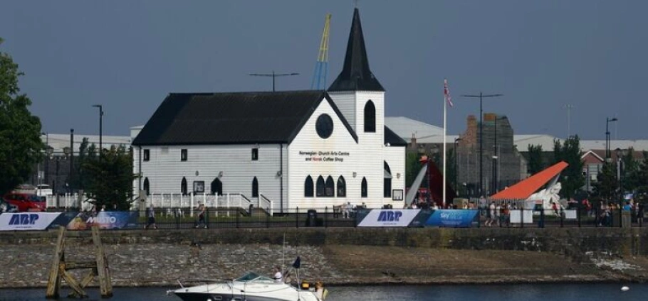 Cardiff Bay Historic Architecture Guided Tour | Historic Norwegian Church Arts Centre and Café on Cardiff Bay waterfront with boat in foreground