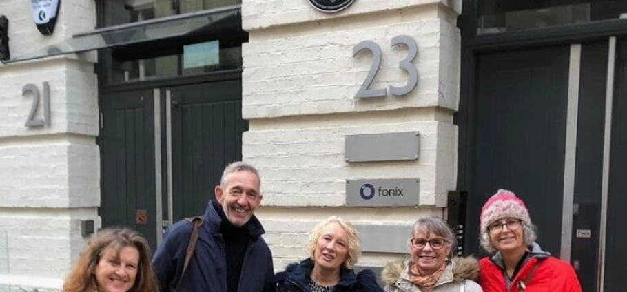 150 Minute David Bowie Trivia Tour | Group of five people smiling in front of a building with the number 23 and a Fonix sign.