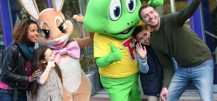 Family posing with cartoon character mascots at Cadbury World Birmingham