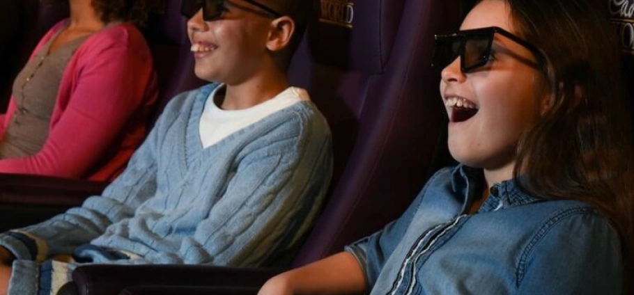 Children enjoying a 3D movie at Cadbury World Birminghamr, wearing 3D glasses and smiling with excitement.