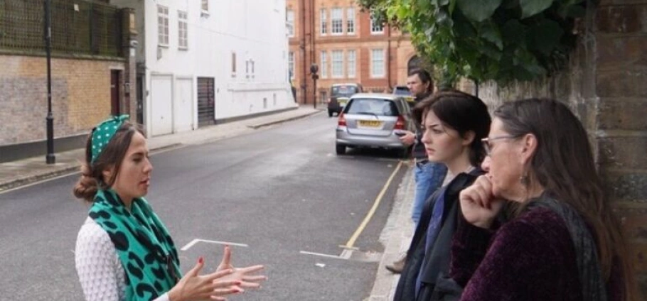 Freddie Mercury Legacy Tour | Tour guide explaining to a group on a city street.