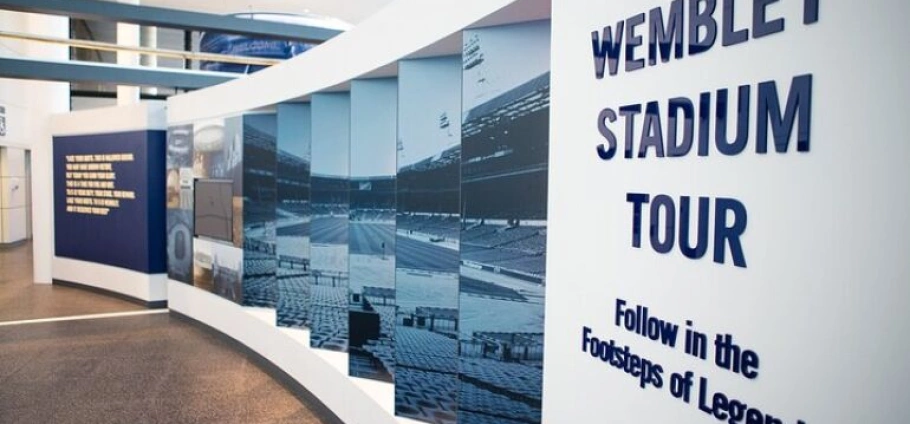 Wembley Stadium tour entrance with wall displays and informational panels.