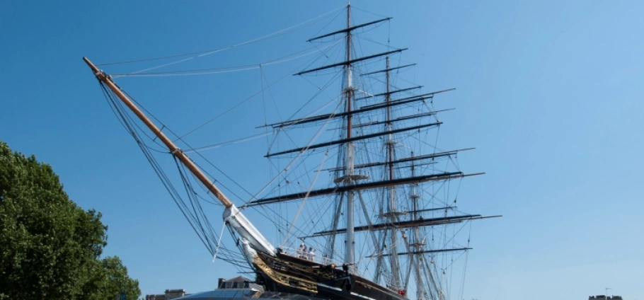 Cutty Sark Afternoon Tea and Boat Tour for Two | Historic sailing ship with tall masts docked at a port on a clear day.