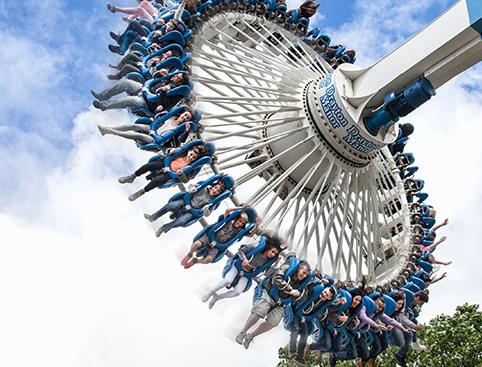 People riding a giant swing ride at an amusement park.