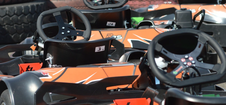 Close-up of orange go-karts parked in a row at Lichfield Go Kart Driving