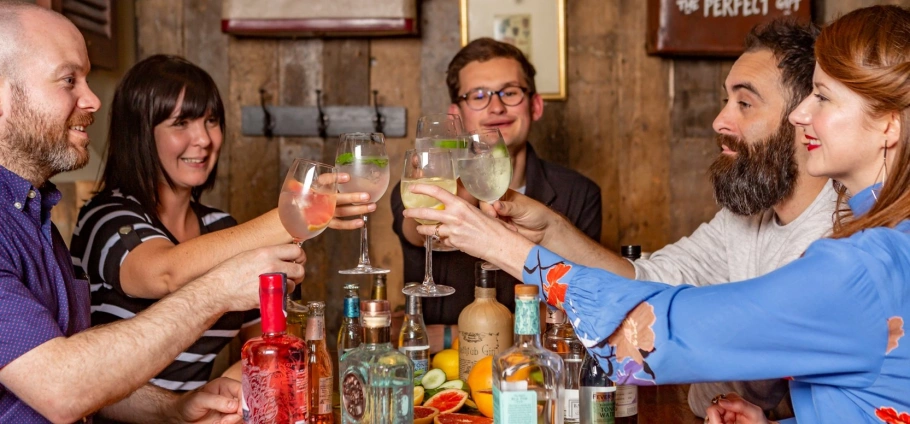 Group of friends toasting with cocktails in a bar setting