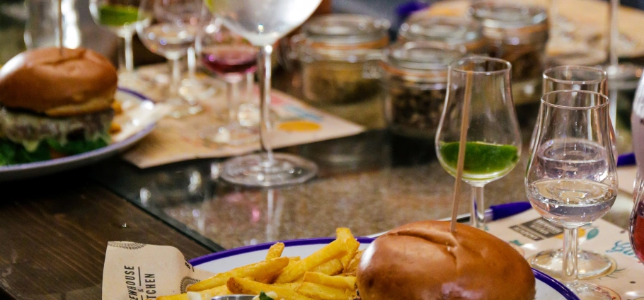 Gourmet burgers with fries and assorted drinks on a restaurant table.