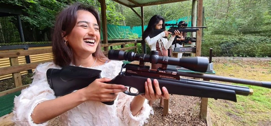 Women enjoying a day at Rifle Shooting Experience Birmingham, holding and aiming air rifles in an outdoor setting.