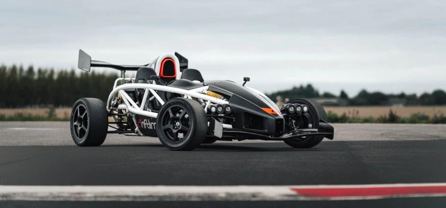 Ultimate Motorsports Race Day Experience in London | Ariel Atom sports car on a racetrack with a blurred background of trees and cloudy sky