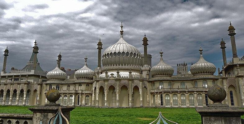 The Royal Pavilion in Brighton, a historic palace with distinctive onion-shaped domes and ornate architecture under a cloudy sky